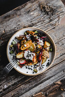 Bratkartoffelsalat mit schwarzen Linsen, Radieschen, Zwiebeln und Ziegenkäse