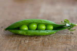 Fresh peas in pod on wooden surface