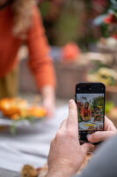 Man photographing woman serving