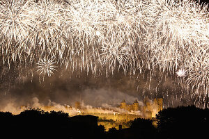 Feuerwerk zum Tag der Bastille mit nächtlich beleuchteter Burg und Festungsmauer; Carcassonne, Languedoc-Rousillion, Frankreich
