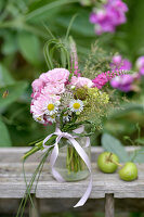 Sommerstrauß mit Rosen (Rosa), Kanadisches Berufkraut (Erigeron canadensis) und Gräsern auf Holztisch