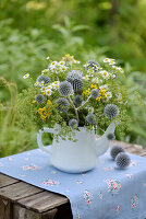 Bunter Sommerstrauß mit Kugeldisteln (Echinops) in alter Teekanne