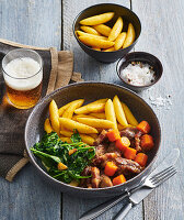 Turkey bites roasted in beer with carrots, spinach and potato noodles