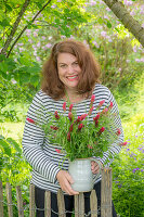 Frau mit Blumenstrauß aus Inkarnat Klee (Trifolium incarnatum) und Gräsern