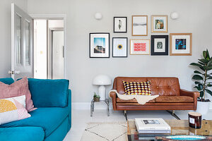 Living room with leather sofa, blue couch and picture wall