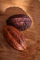 Whole cocoa fruits on wooden background