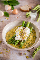 Herb scrambled eggs with green asparagus and poached egg