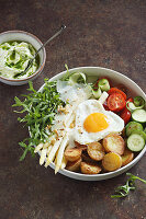Asparagus with fried egg, roast potatoes, rocket and vegetables