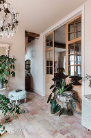 Living area with plants, terracotta tiles and chandelier