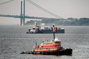 Tugboat and barge in upper New York Bay with Verrazzano-Narrows Bridge and Staten Island in background< New York City, New York, USA