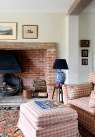 Gemütliche Leseecke mit kariertem Sessel und Kamin im Landhausstil