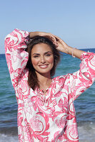 Woman in floral tunic on the beach