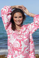 Woman in floral tunic on the beach