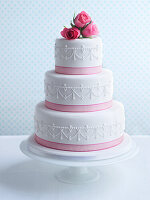 Three-tier white and pink wedding cake