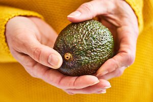Avocado in Händen gehalten