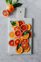 Slices of oranges and blood oranges on a marble board