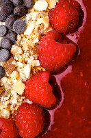 Açaí-Bowl mit Himbeeren, Nüssen und Schokotropfen