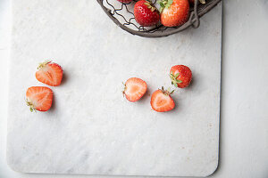 Sliced strawberries on a white marble slab