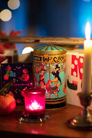 Weihnachtlich dekorierter Tisch mit Kerzen, Weihnachtskarten und Vintage-Geschenkdose