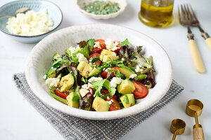 Salad with avocado, tomatoes, lettuce and feta cheese