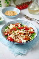 Salad with salmon, tomatoes, spinach, feta and pine nuts