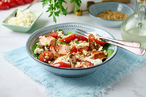 Salad with salmon, tomatoes, spinach, feta and pine nuts