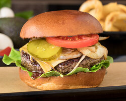 Cheeseburger mit gegrillten Zwiebeln und Gemüse