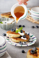 Blueberry pancakes with maple syrup and fresh blueberries