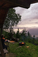 Abendessen auf Berghütte mit Lagerfeuer und Bergblick