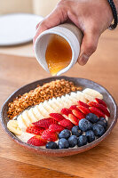 Müsli-Bowl mit Beeren, Banane und Honig