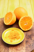 Whole and halved oranges with orange zest