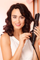 Young woman doing curls with curling iron