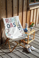 Liegestuhl mit 'Ruheoase'-Schriftzug auf Terrasse