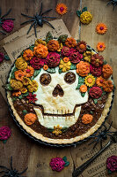 Halloween-Kuchen mit Totenkopf- und Blüten-Dekoration