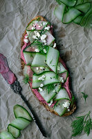 Vollkornbrot mit Rote-Bete-Hummus, Gurkenstreifen und Feta