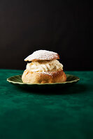 Semla-Brötchen mit Sahne und Puderzucker auf einer grünen Fläche