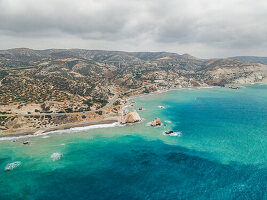 Luftaufnahme des wunderschönen Aphrodite-Strandes mit ruhiger Küstenlinie und zerklüfteten Hügeln, Kouklia, Paphos, Zypern.