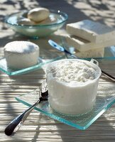 Frischkäse im Abtropfbehälter, Käse im Hintergrund