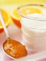 Marmalade on a spoon with a jar of jam sugar
