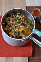 Preparing a broth with rice, sweetcorn, red kidney beans and Espelette pepper
