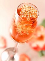 Glass of fizzy rosé wine with pearls