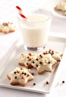 Star-shaped nut biscuits with chocolate pearls served with a glass of milk
