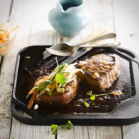 Cooking Asian-style beef a la plancha with coriander and strips of carrots and cucumber