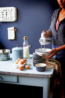 Frau mit Mixer beim Zubereiten eines Soufflés