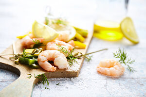 Garnelen mit zweierlei Paprika, Zitrone, Dill und Fleur de sel auf einem Schneidbrett