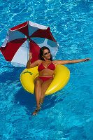 Frau im Wasser, mit Sonnenschirm und Reifen