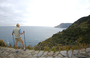 A woman enjoying the views while hiking, Cinque Terre, Italy