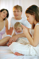 Young family sitting on bed