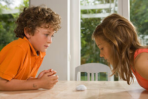 Girl and boy playing Cotton Wool Blowing, children's birthday party