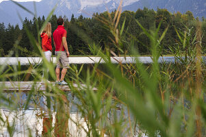 Young couple on jetty, lake Lautersee, Mittenwald, Werdenfelser Land, Upper Bavaria, Germany